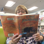 Photo of staffer Rose reading the book A Tale Magnolious.