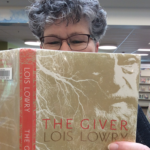 Photo of staffer Nancy holding up the book The GIver
