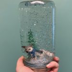 Photo of a mason jar snow globe containing an evergreen and dog figurine