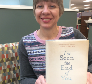 Staff person holding recommended book