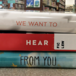 Stack of book spines that read "we want to hear from you"