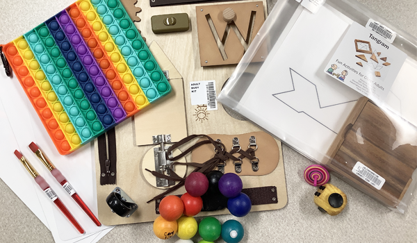 Various objects, including magnetized balls in a rainbow of colors, paintbrushes, and fidget toys.